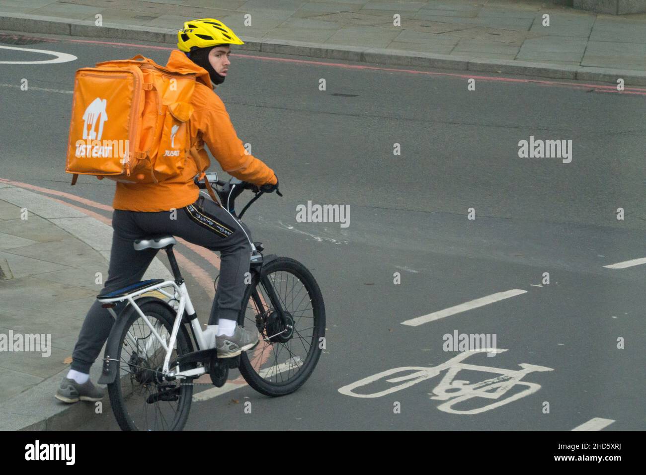 London, Großbritannien, 3. Januar 2022: Ein Just Eat Delivery Rider auf einem Fahrrad wartet auf der Fahrradspur an einer Kreuzung. Neben Uber Eats und Deliveroo ist die Lieferung von Heißnahrung an Kunden ein Wachstumssektor. Anna Watson/Alamy Live News Stockfoto