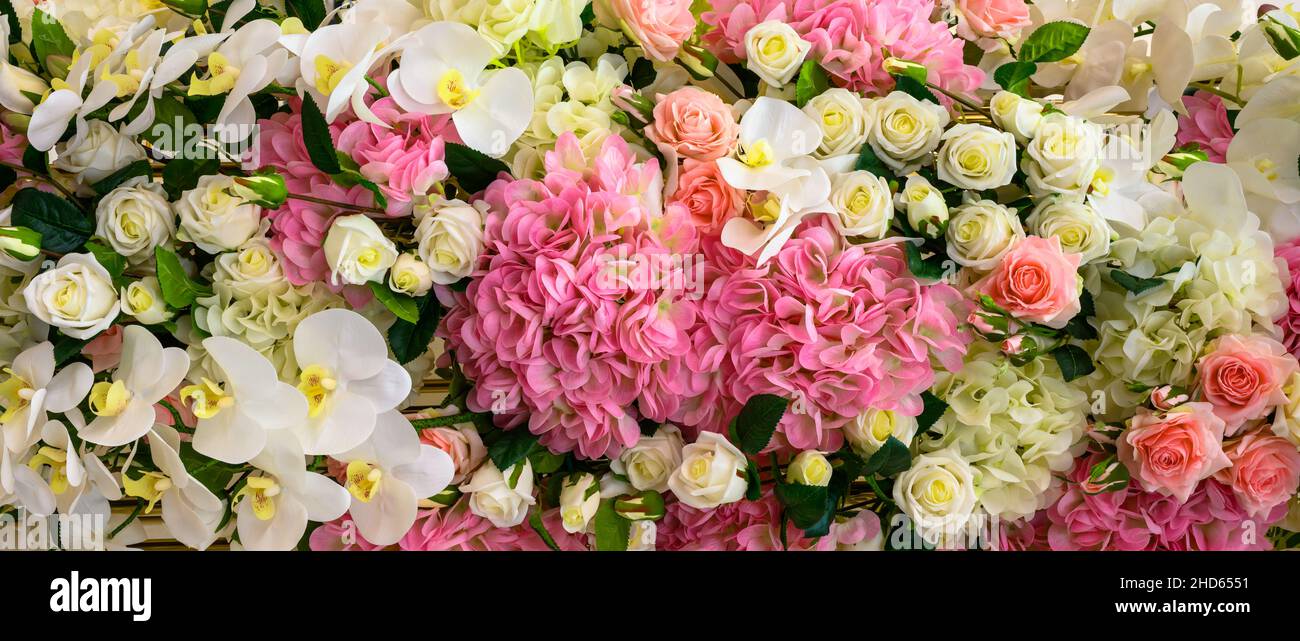Verschiedene Blumen im Hintergrund, Panoramablick von oben auf frische Orchideen, Rosen und andere Blumen. Schönes Pastellmuster mit schönen Blumen. Natur, Hochzeit, Stockfoto