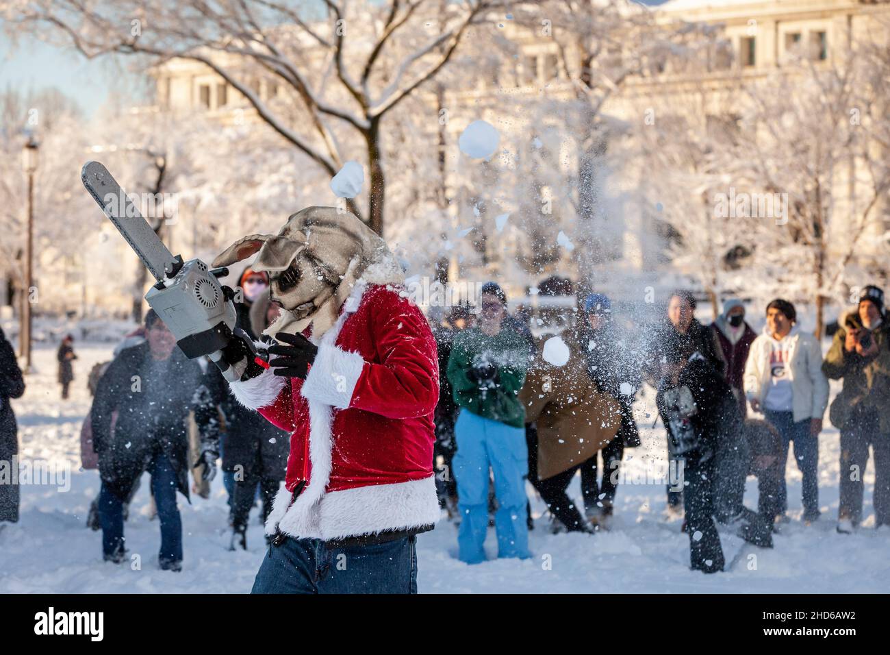 Washington, DC, USA, 3. Januar 2022. Im Bild: Ein Mann, der als Bunnyman in einem Weihnachtsmantel gekleidet ist, streut mit seiner Kettensäge zwischen den Gruppen an einer großen Schneeballschlacht in der National Mall an. Der Kampf ereignete sich, nachdem ein unerwarteter Schneesturm etwa 8 cm auf Schnee in Washington, DC, geworfen hatte und von der DC Snowball Fight Association angekündigt wurde. Kredit: Allison Bailey / Alamy Live Nachrichten Stockfoto