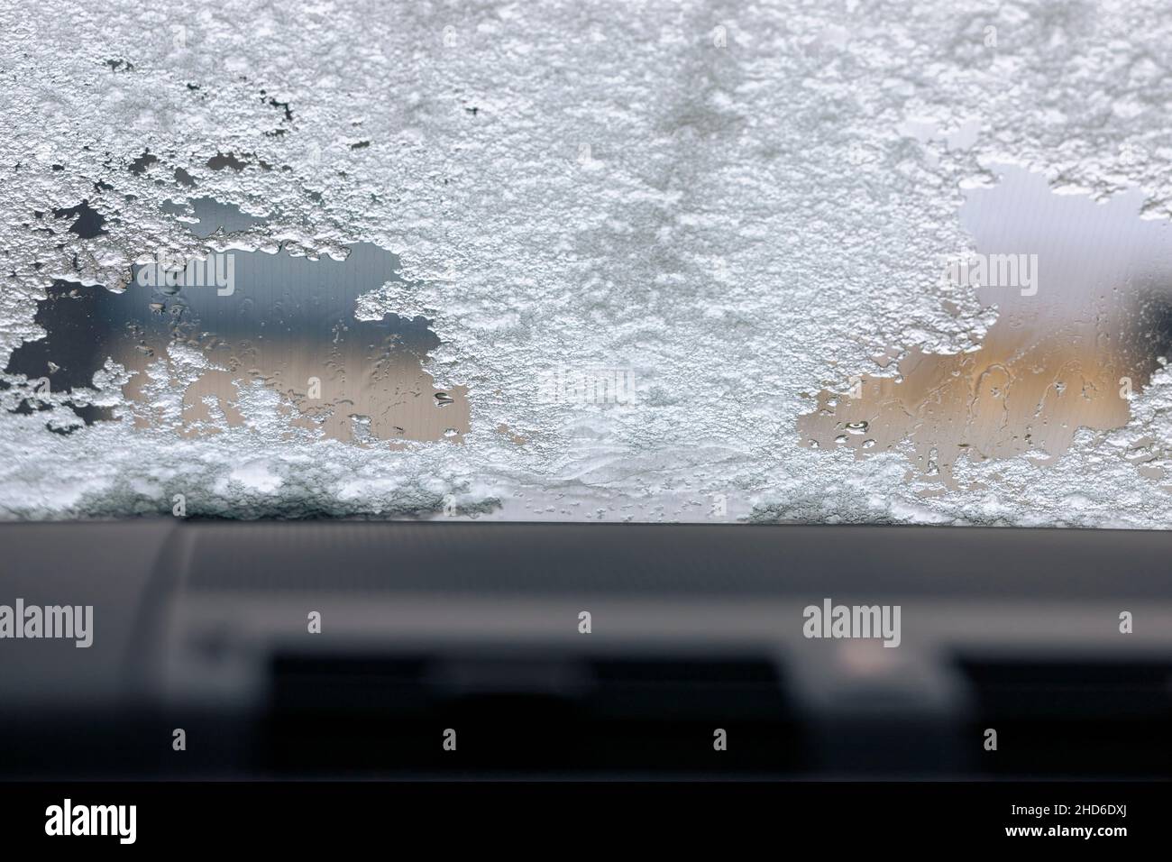 Abtauen der Windschutzscheibe mit schmelzendem Eis, Blick von innen Stockfoto