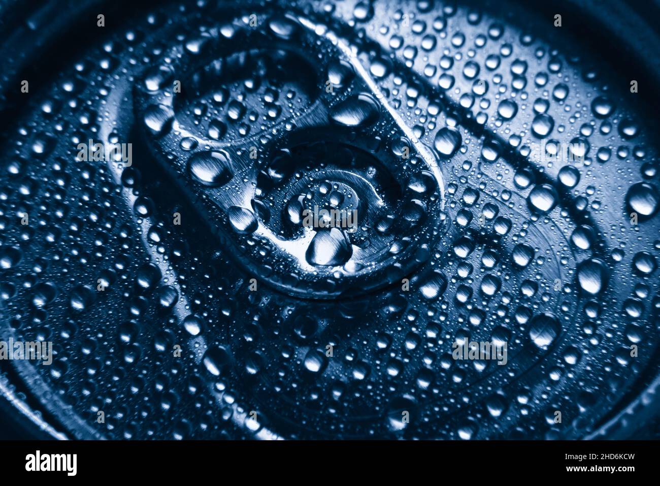 Nahaufnahme eines Aluminiumgetränks kann mit Wassertropfen trinken. Geschlossene Bierkäuze mit Wassertropfen kondensieren. Kaltblaues Bild. Selektiver Fokus. Stockfoto