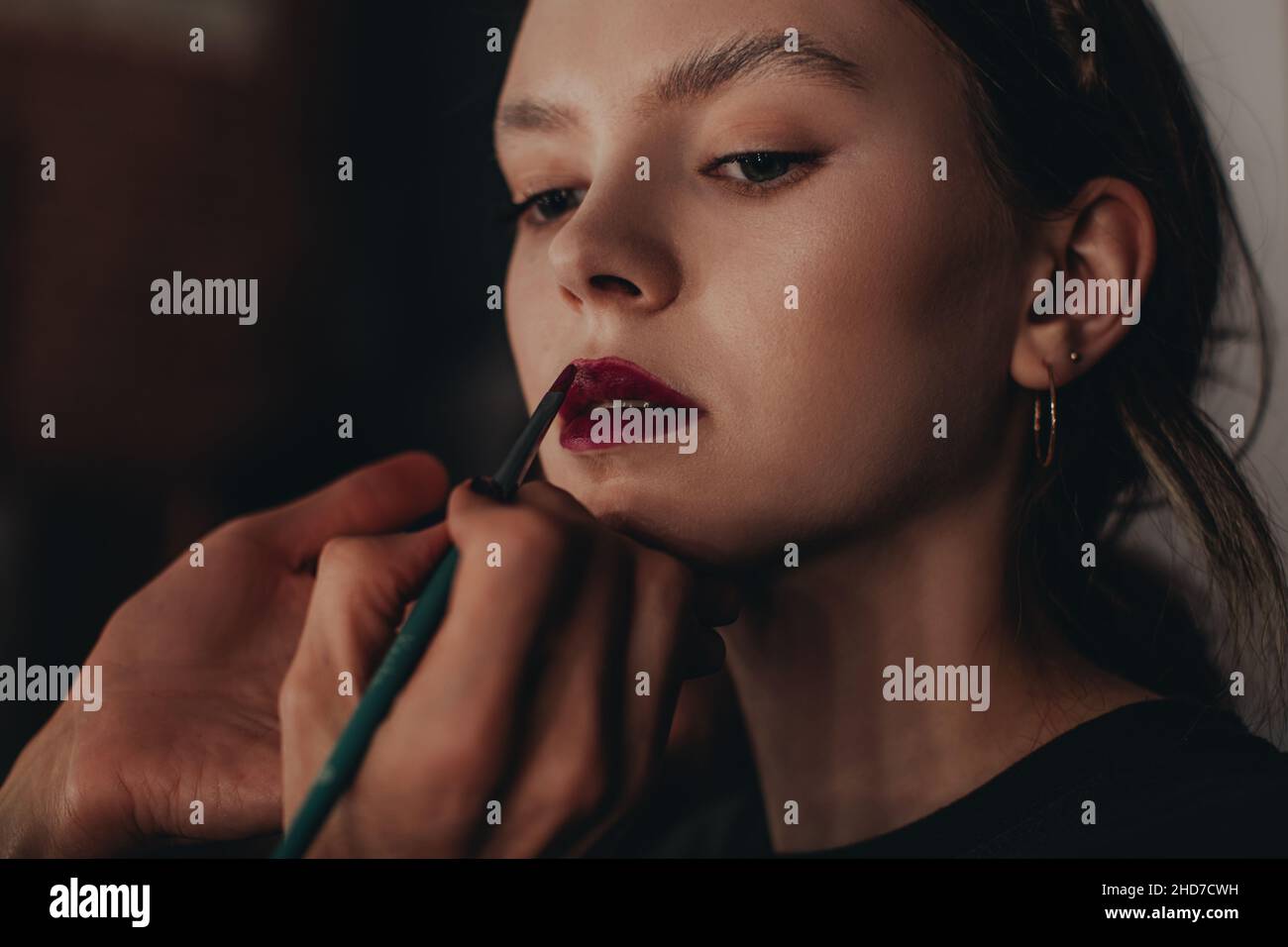 Make-up-Künstler tun Lippen Make-up zu jungen Mode-Modell bei der Fashion Week Backstage Stockfoto