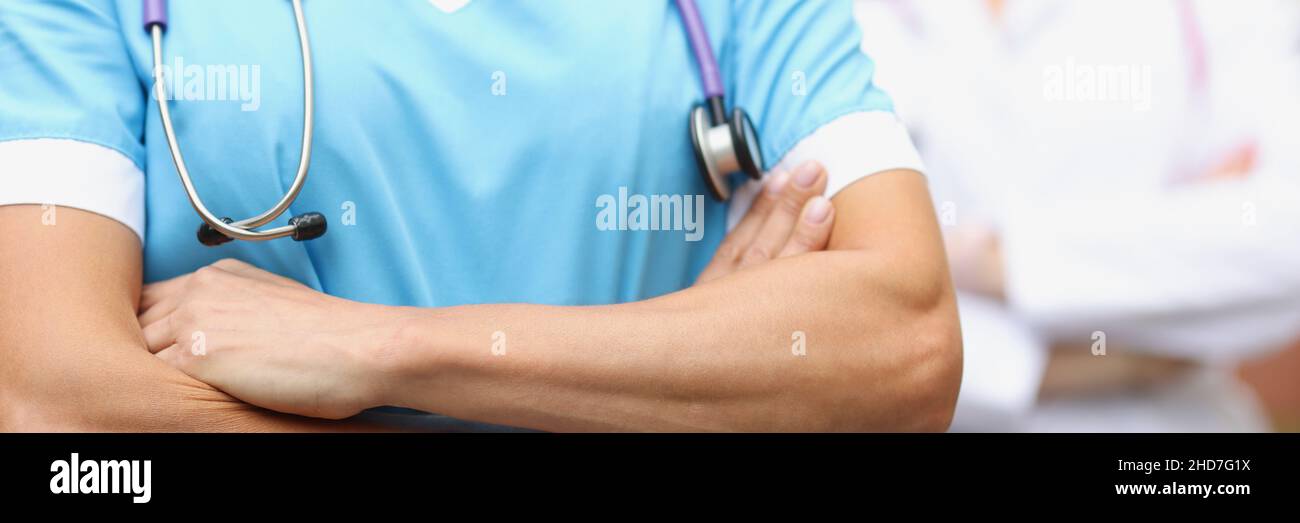 Zwei Ärzte stehen selbstbewusst mit gefalteten Händen aus der Nähe Stockfoto