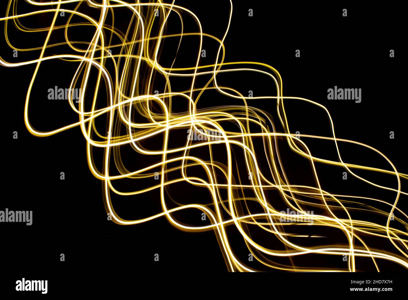Abstraktes goldenes Wirbeln vor schwarzem Hintergrund, helles Gemälde gelbes Wirbeln. Langzeitbelichtung. Stockfoto