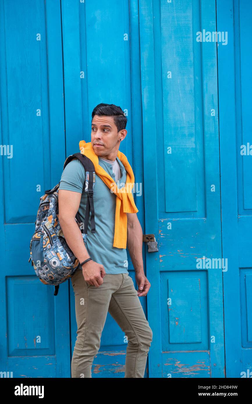 Glücklicher und junger mann aus lateinamerika, der an einer blauen Tür steht, Panama Stockfoto
