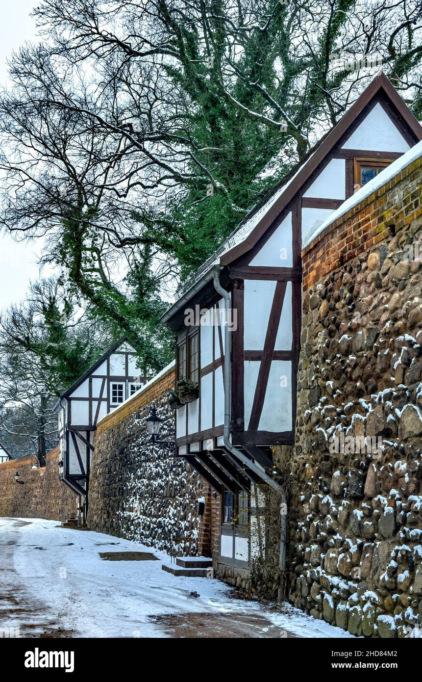 Mittelalterliche Stadtmauer mit Wieck-Häusern (norddeutsche Variante eines Wachhauses) im Winter, Neubrandenburg, Deutschland. Stockfoto