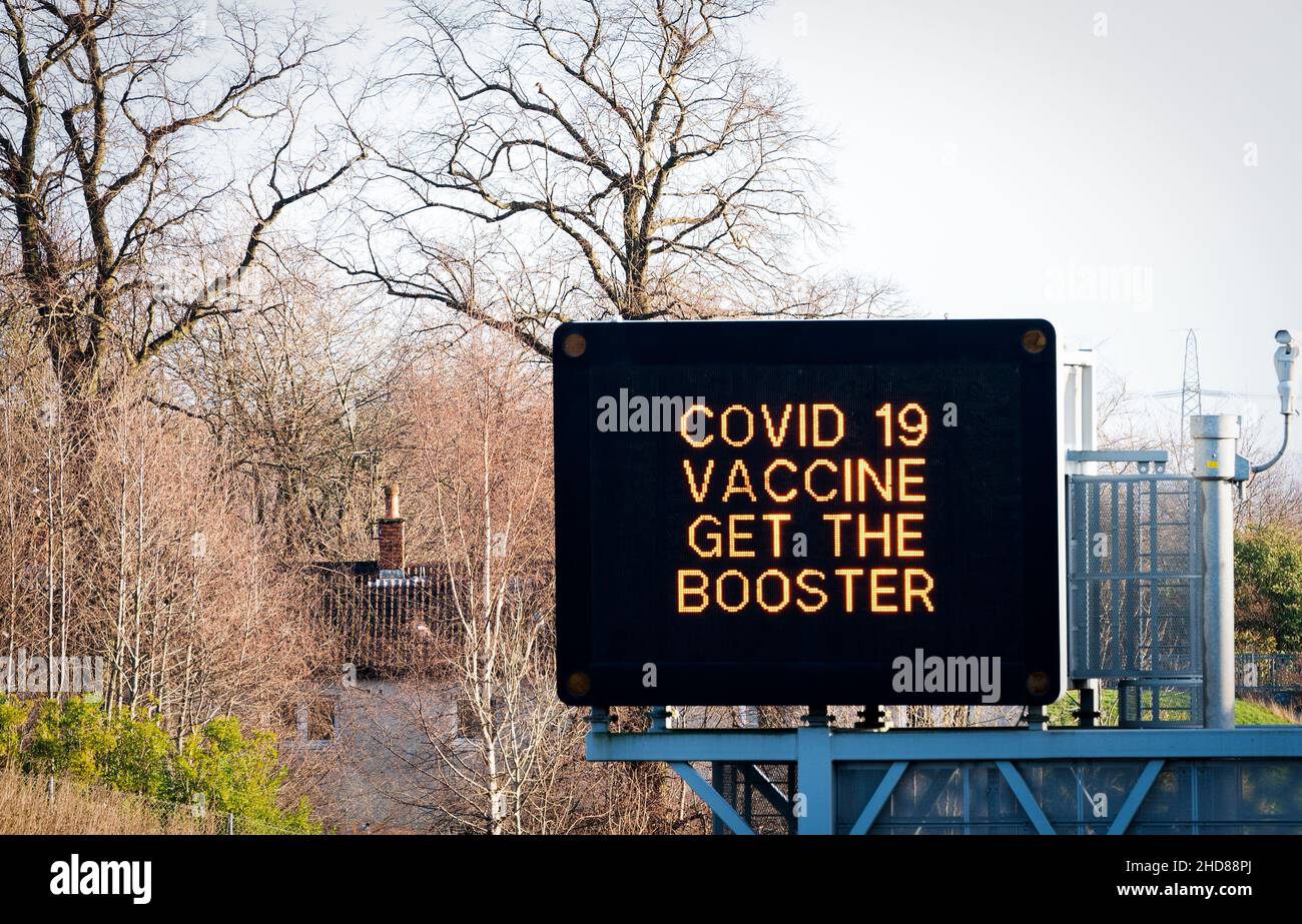 Informationsschilder über der Autobahn M8 in Glasgow lauten „Covid 19 Vaccine Get the Booster“, da das Coronavirus-Booster-Programm in ganz Großbritannien fortgesetzt wird. Bilddatum: Dienstag, 4. Januar 2022. Stockfoto