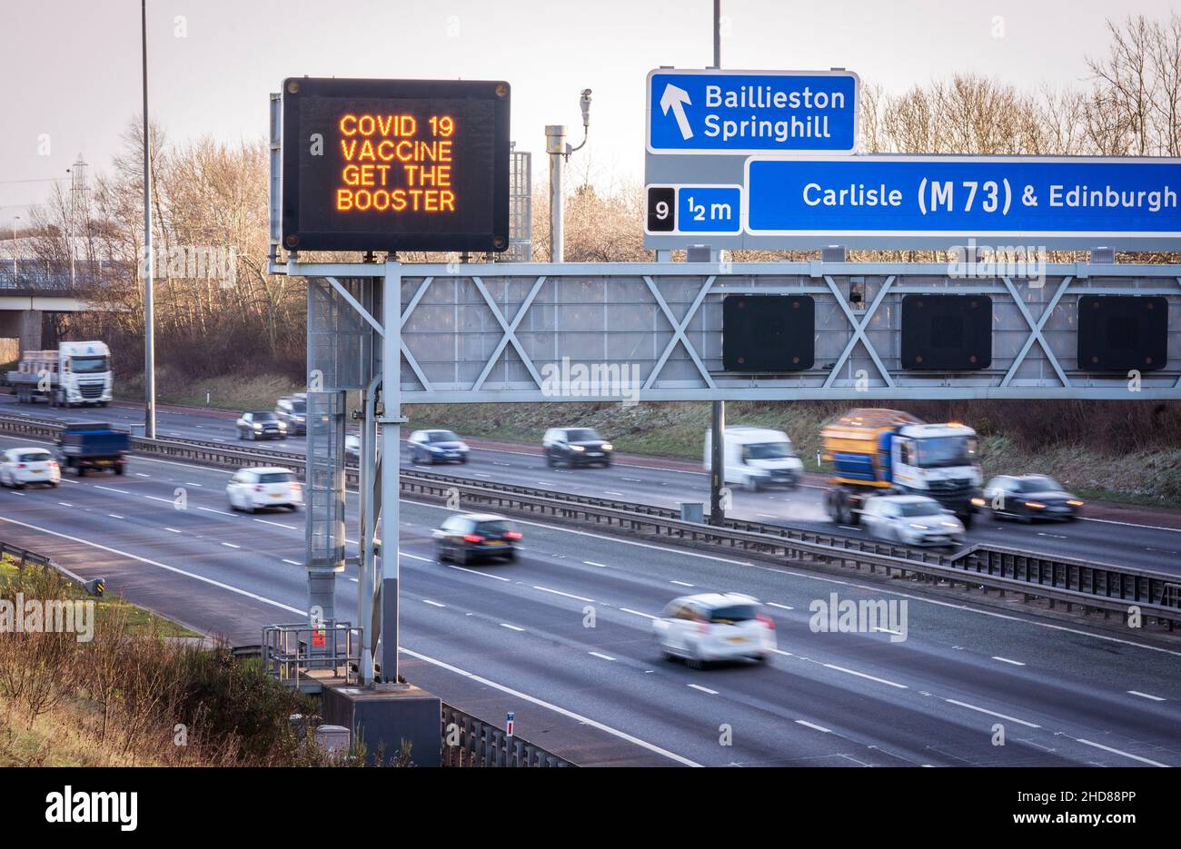 Informationsschilder über der Autobahn M8 in Glasgow lauten „Covid 19 Vaccine Get the Booster“, da das Coronavirus-Booster-Programm in ganz Großbritannien fortgesetzt wird. Bilddatum: Dienstag, 4. Januar 2022. Stockfoto