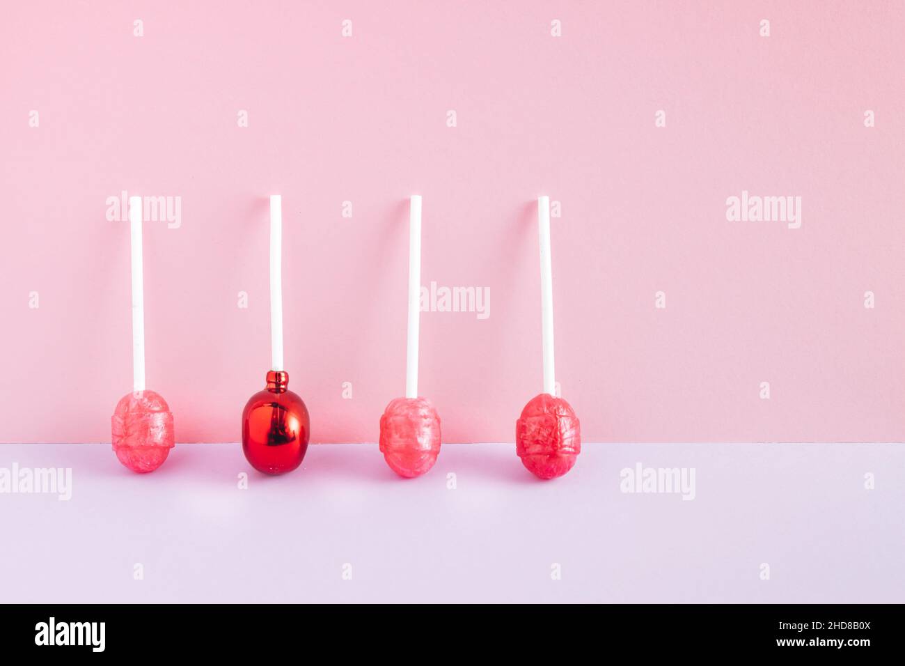 Lutscher auf dem pastellrosa und violetten Hintergrund. Abstrakte süße Komposition. Helle Süßigkeiten Idee. Stockfoto