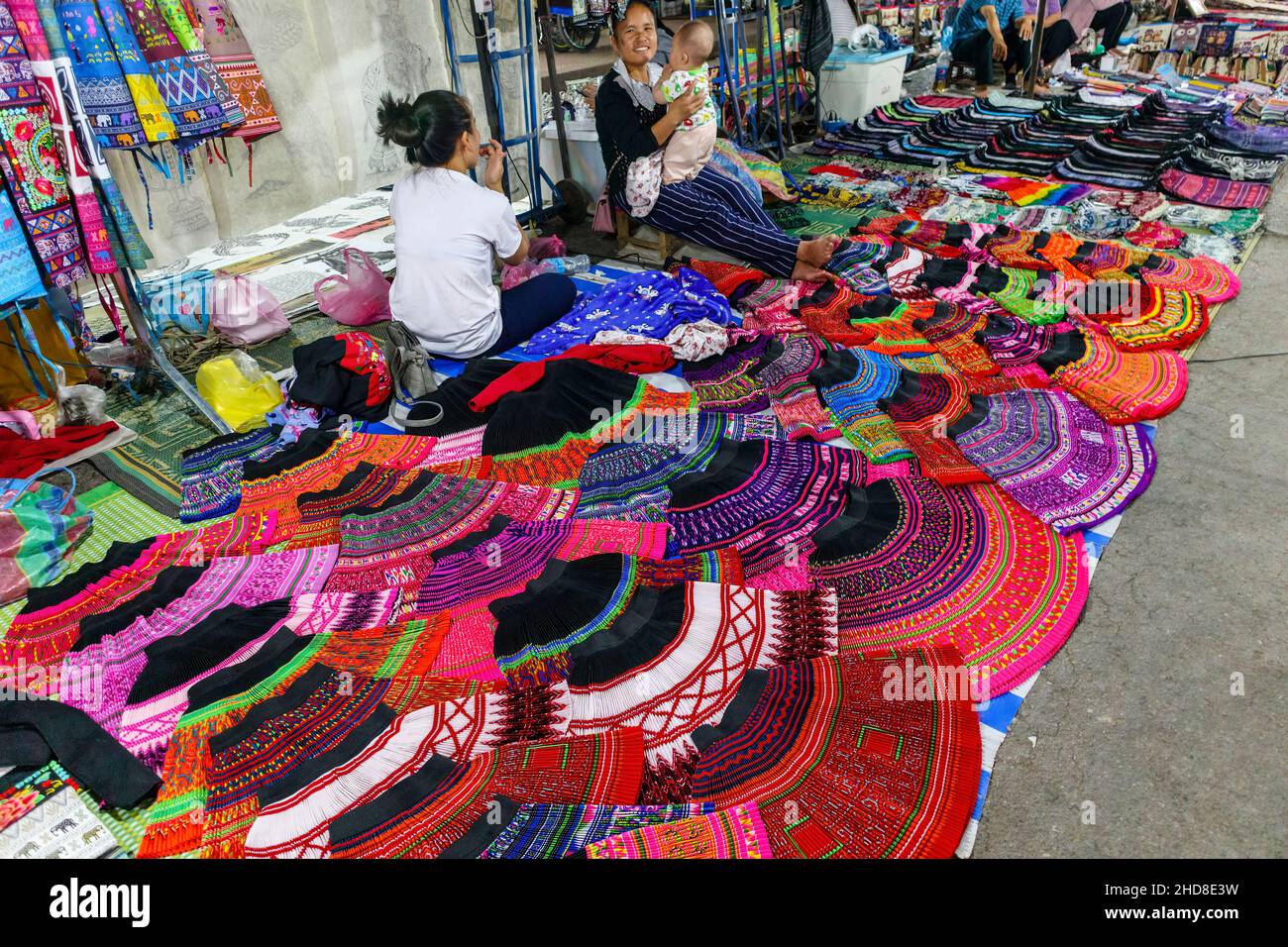 Farbenfrohe Röcke und Stoffe im lokalen Stil werden auf dem Nachtmarkt in  der Fußgängerzone im Zentrum von Luang Prabang, im Norden von Laos,  Südostasien, ausgestellt Stockfotografie - Alamy