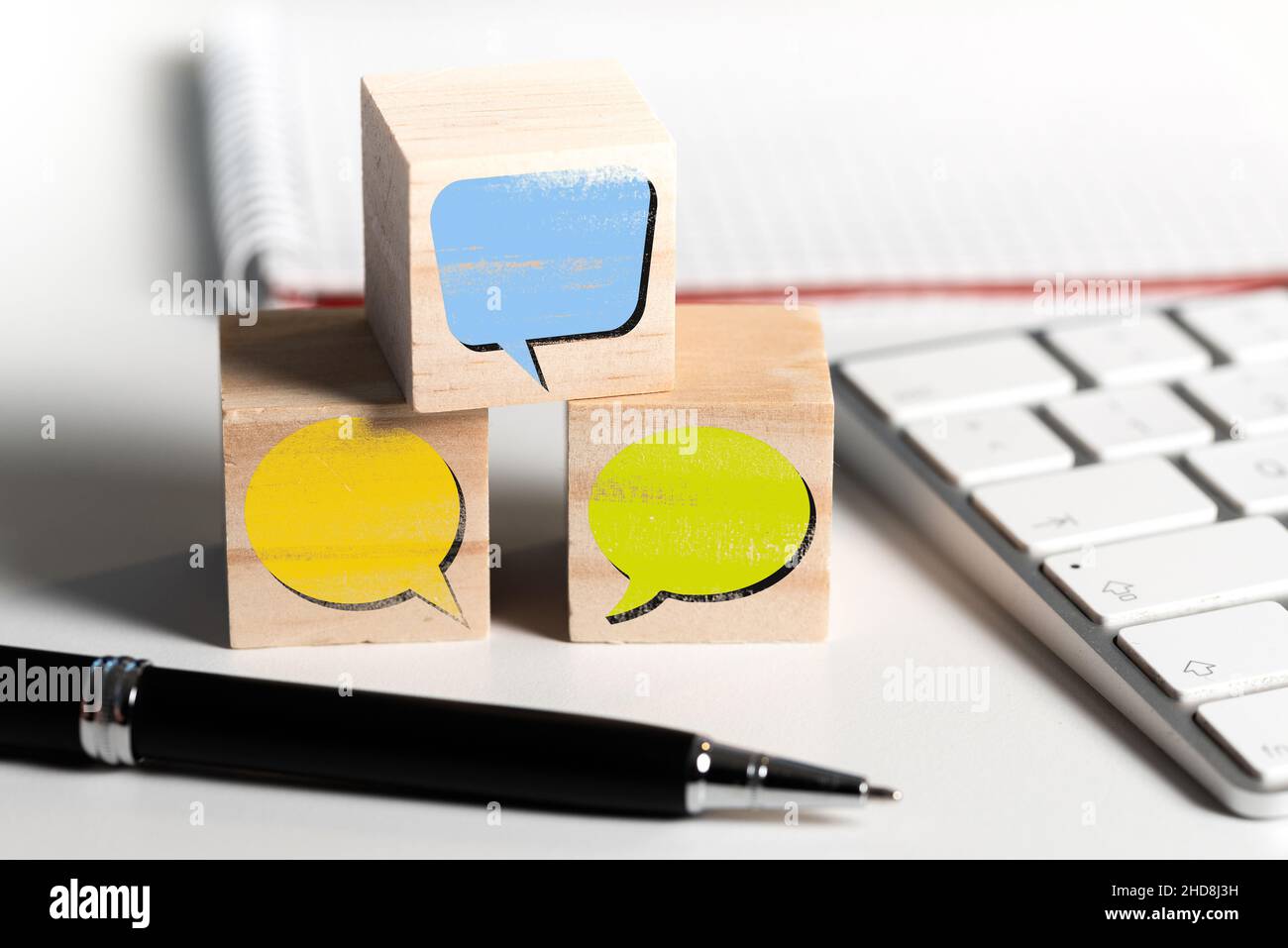 Leere Sprechblasen auf Holzblöcken am Schreibtisch, Kommunikationskonzept Stockfoto