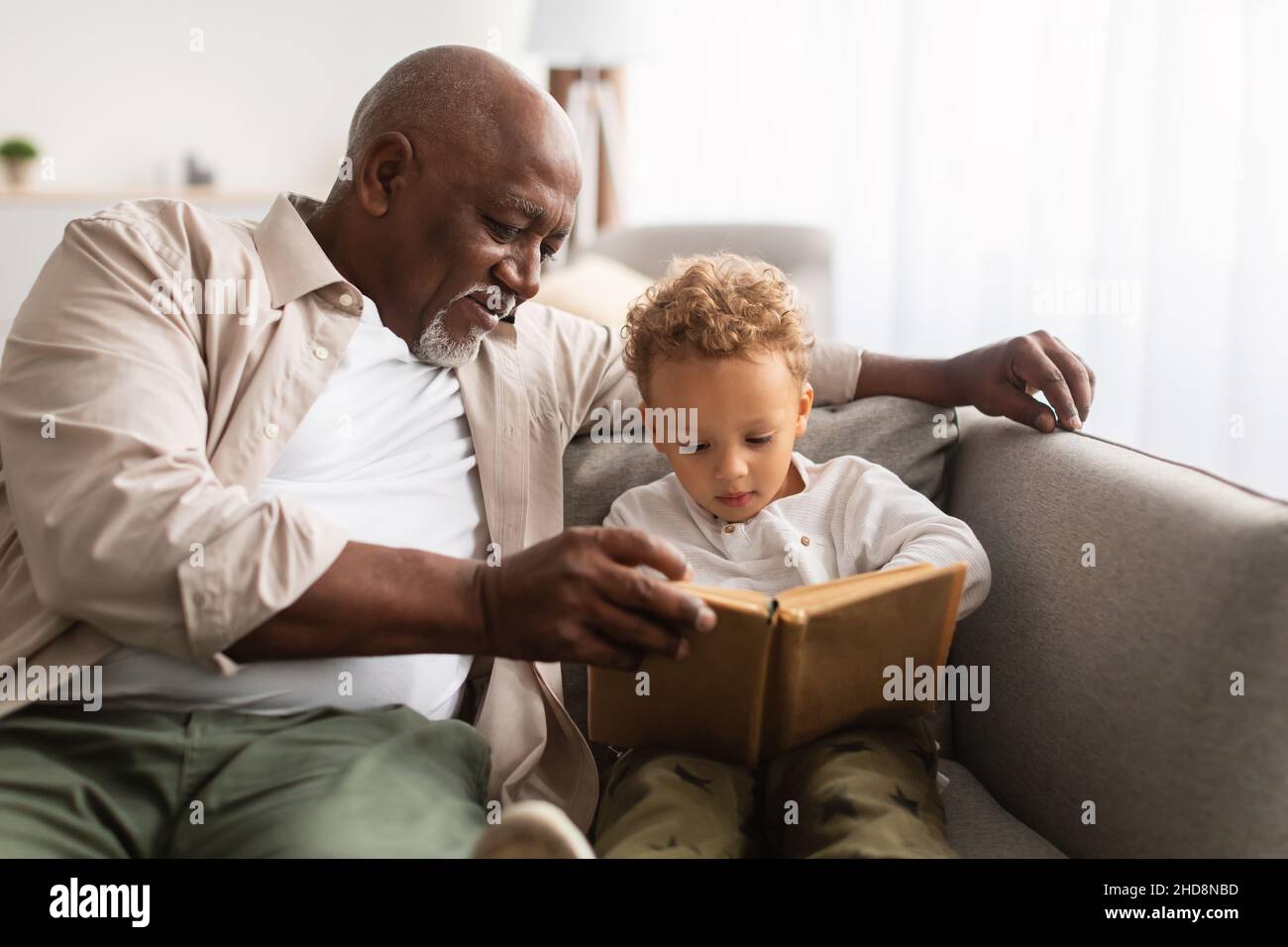 Afroamerikanischer Opa Und Enkel Lesung Buch Zusammen Zu Hause Stockfoto