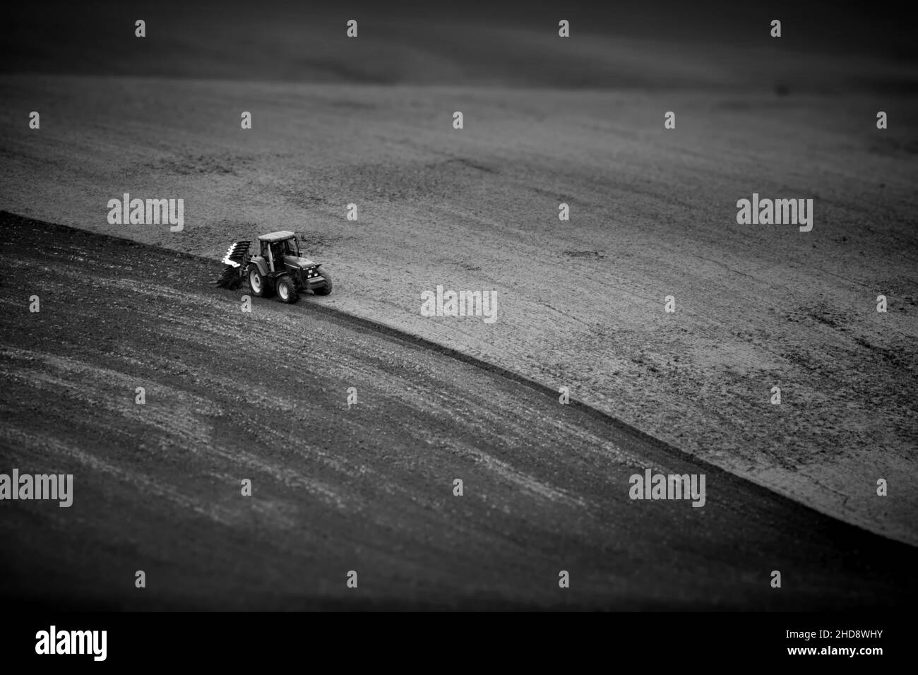 Graustufen eines Traktors auf einem landwirtschaftlichen Feld in Mähren, Tschechische Republik Stockfoto