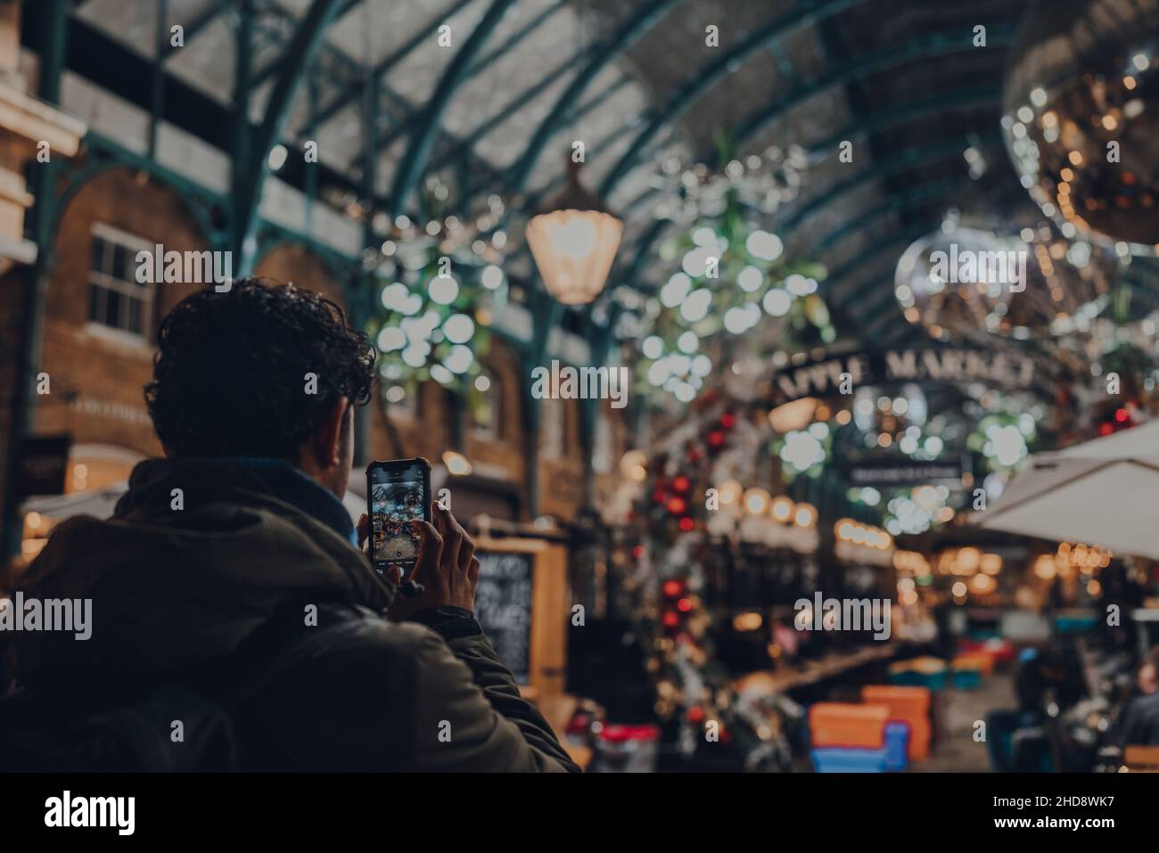 London, Großbritannien - 23. November 2021: Mann fotografiert Weihnachtsschmuck auf dem Covent Garden Market, einer der beliebtesten Touristenattraktionen Londons, o Stockfoto