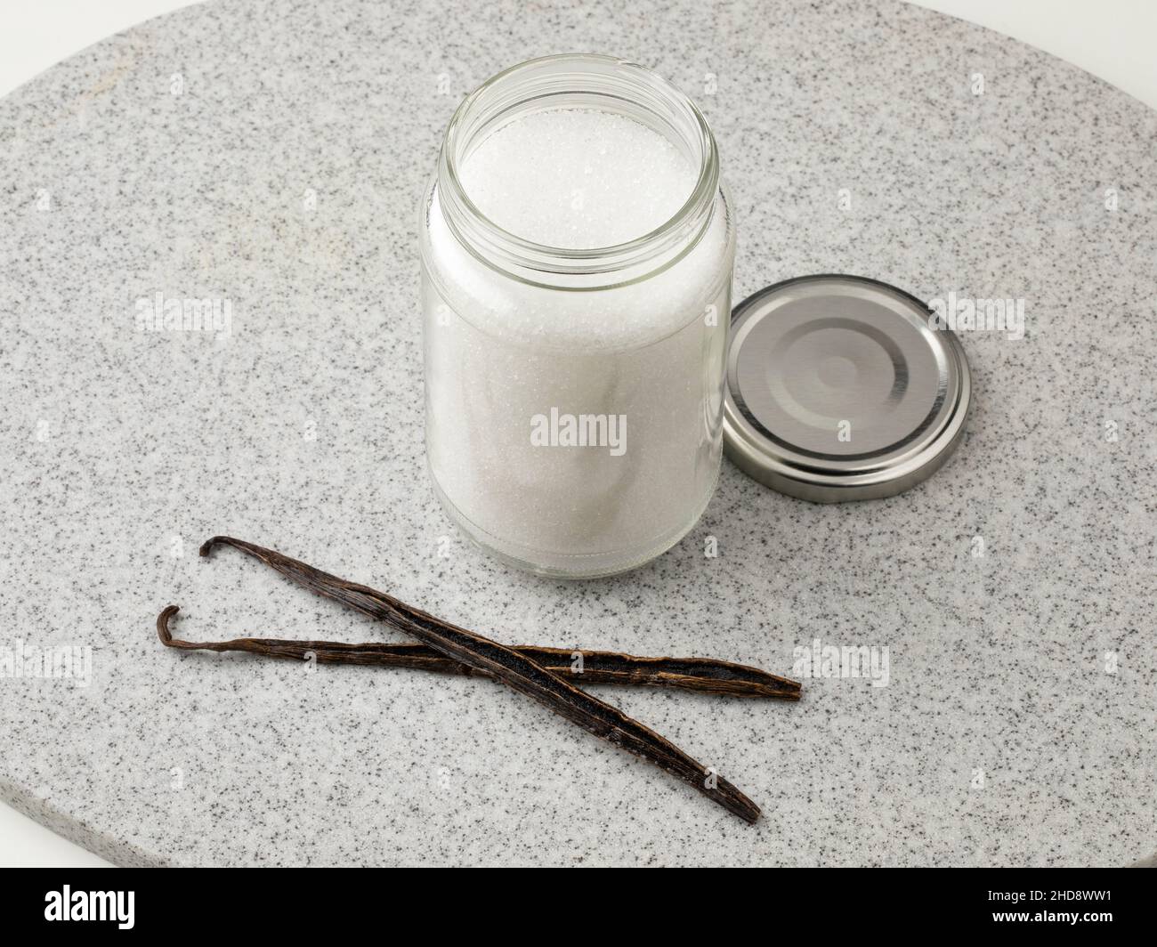 Vanillesticks vor einem Glasgefäß mit Zucker zur Herstellung von Vanillezucker verpaaren Stockfoto
