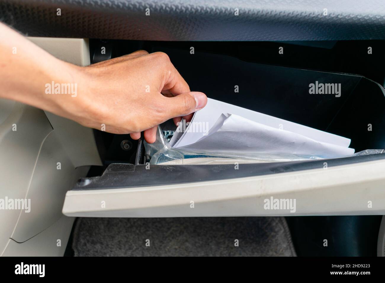 Rühren von Dokumenten in einem Handschuhfach Stockfoto