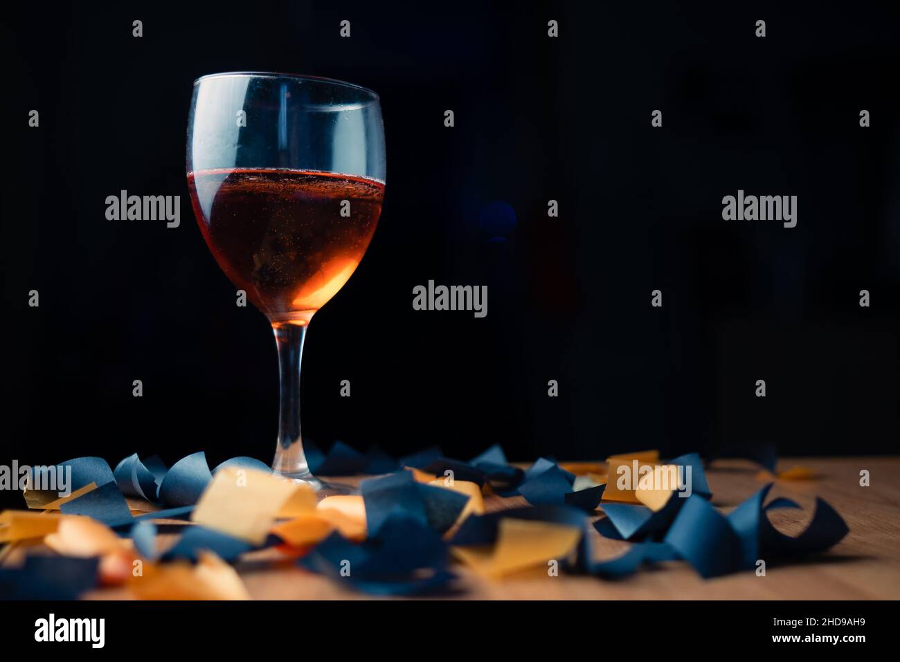 Glas roten Sekt auf schwarzem Hintergrund mit Süßigkeiten Stockfoto