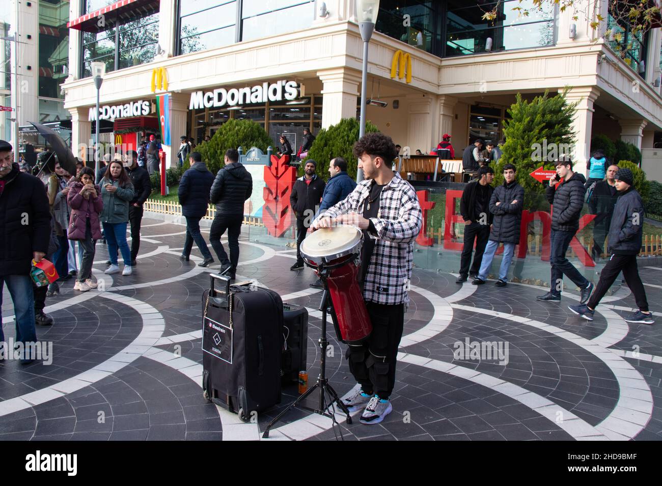 Street Drummer auf dem zentralen Platz von Baku - Aserbaidschan: 31. Dezember 2021. Ein Straßenmusiker spielt tom-tom auf einer Trommel. Stockfoto