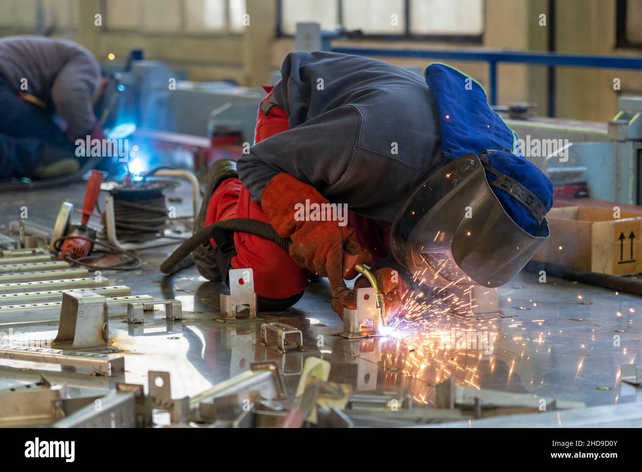 Arbeiter Mit Schweißhelm Und Schutzkleidung Schweißzugkonstruktion In Der Eisenbahnfabrik. Stockfoto