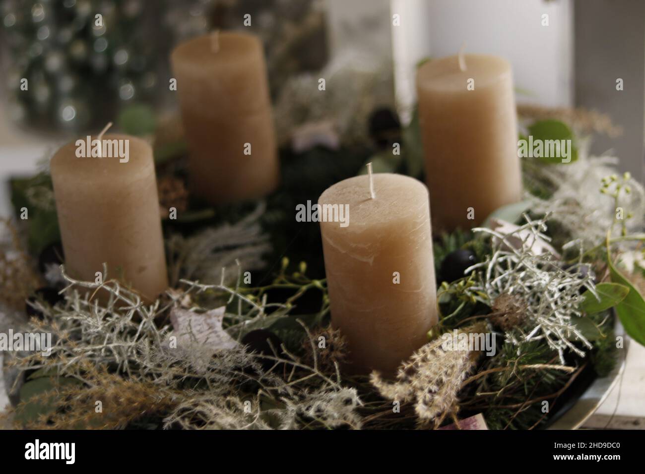 Selektive Fokusaufnahme einer großen Kerze, einer spanischen Moospflanze, einem weißen Stern und Weihnachtsdekorationen Stockfoto