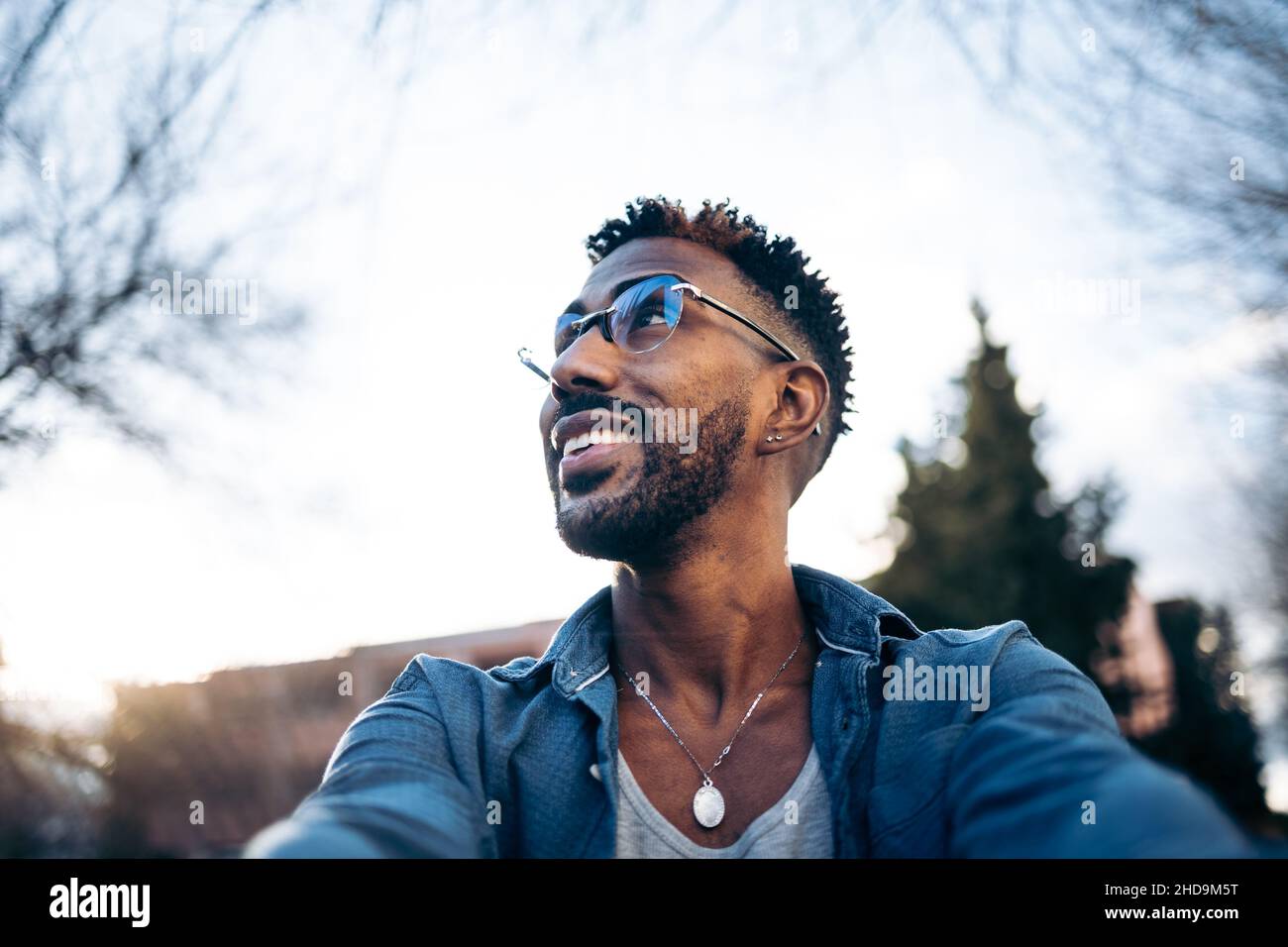 Schöner Latino-Mann mit Brille, der mit seinem Smartphone auf der Straße ein Selfie gemacht hat Stockfoto