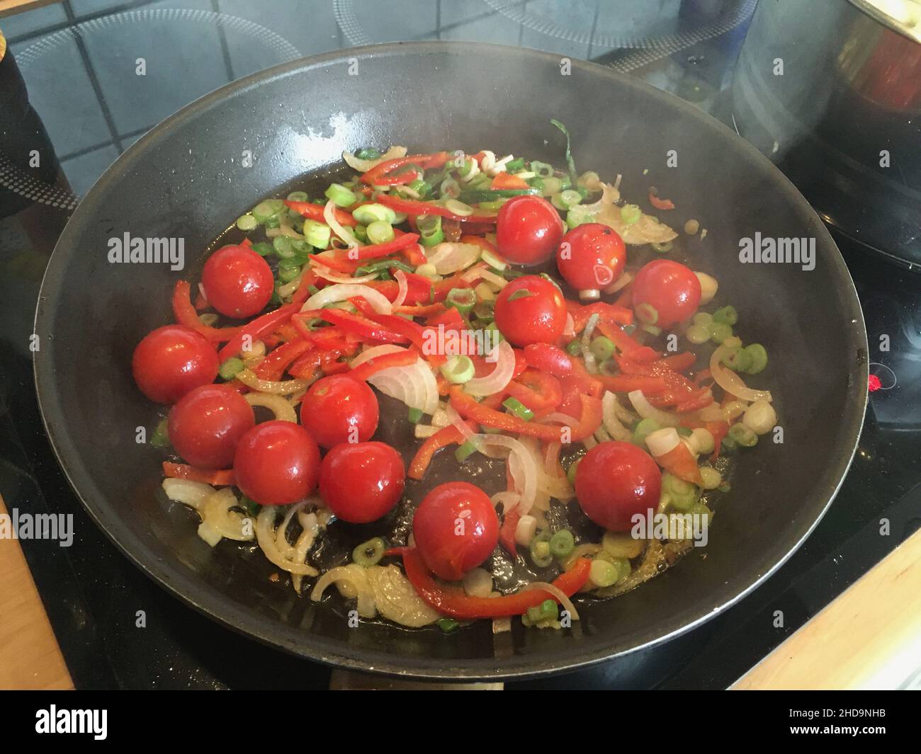 Tomaten, Rindfleisch, Zwiebel und Gewürze in der Pfanne gebraten Stockfoto