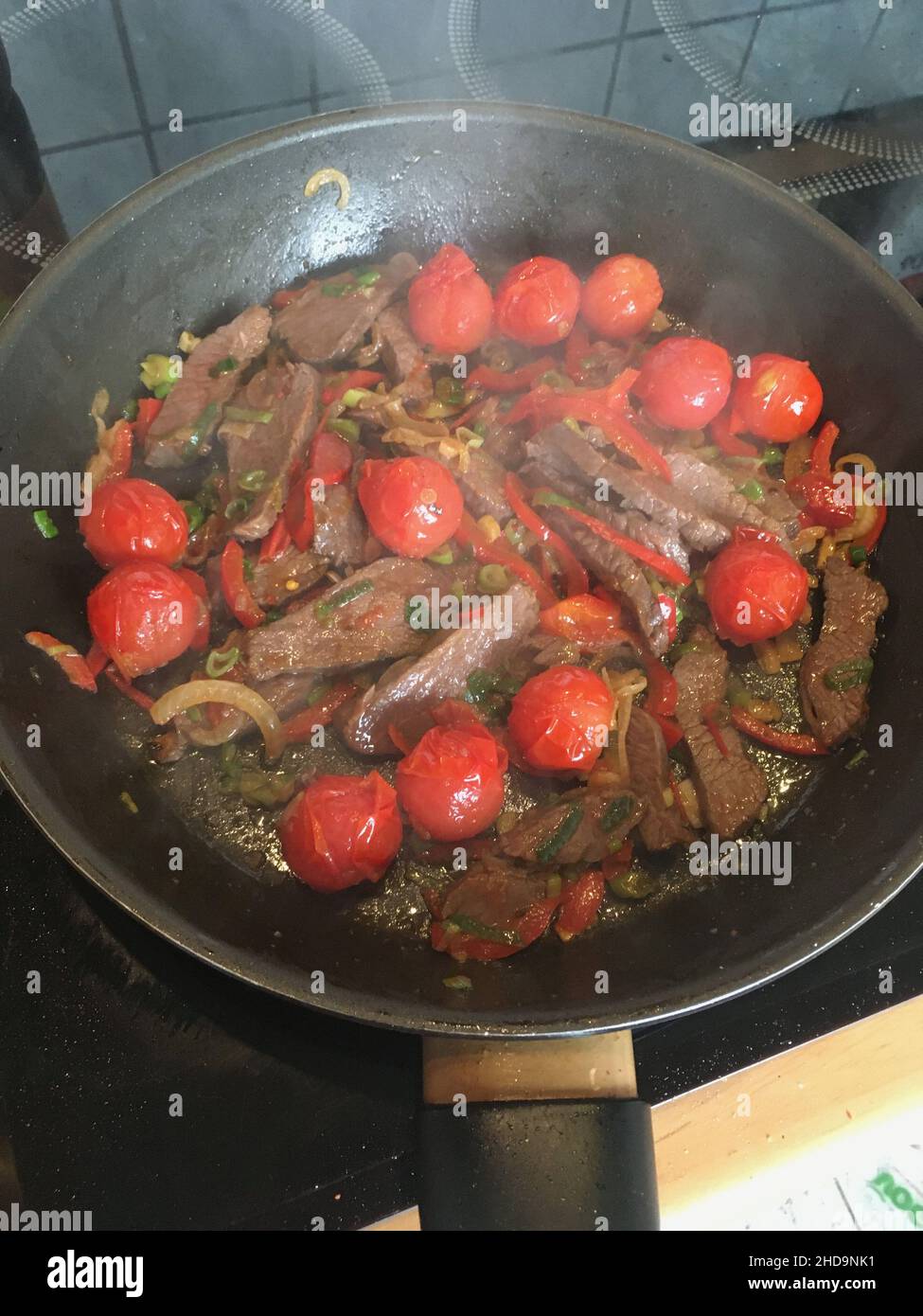 Tomaten, Rindfleisch, Zwiebel und Gewürze in der Pfanne gebraten Stockfoto