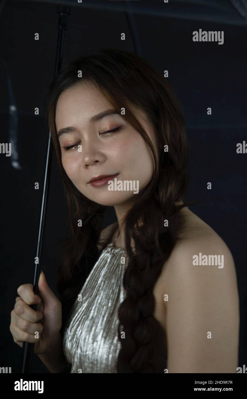 Porträt einer niedlichen und schönen jungen Frau aus Vietnam mit einem Regenschirm Stockfoto