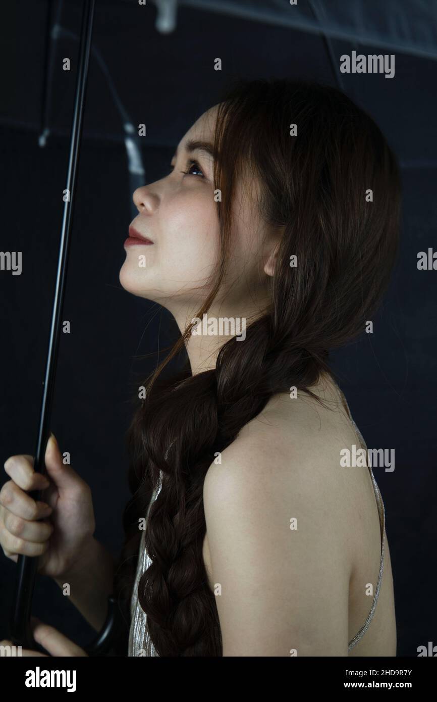 Porträt einer niedlichen und schönen jungen Frau aus Vietnam mit einem Regenschirm Stockfoto