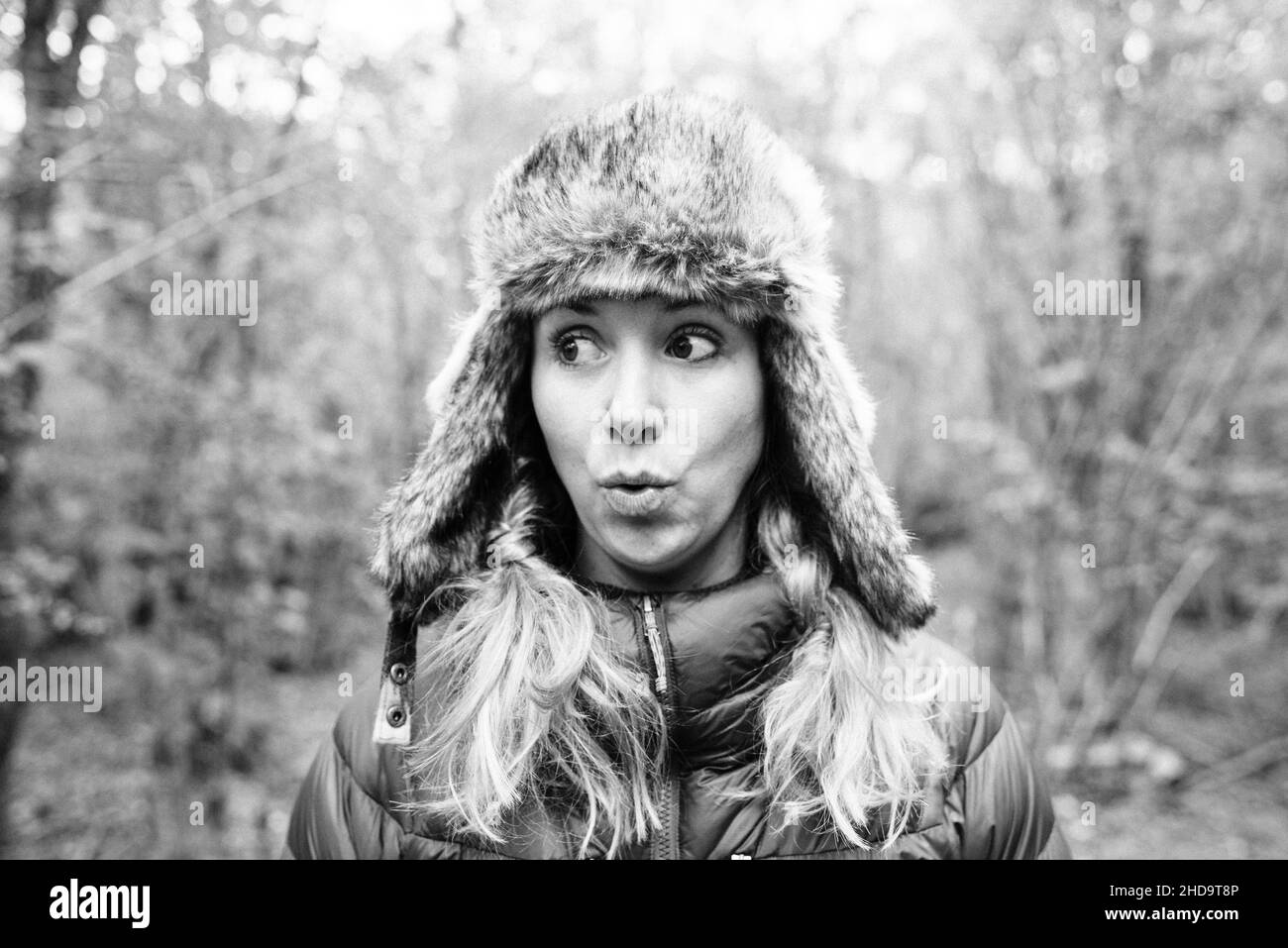 Porträt einer Frau, die draußen im Wald einen lustigen Ausdruck pulling Stockfoto