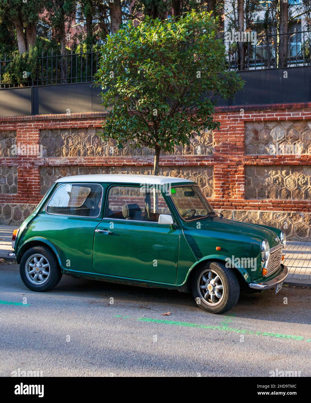 Klassischer grüner Mini an einem sonnigen Tag auf der Straße geparkt Stockfoto