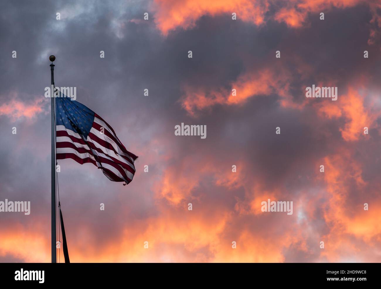 Die amerikanische Flagge gegen einen feuerroten Sonnenuntergangshimmel Stockfoto