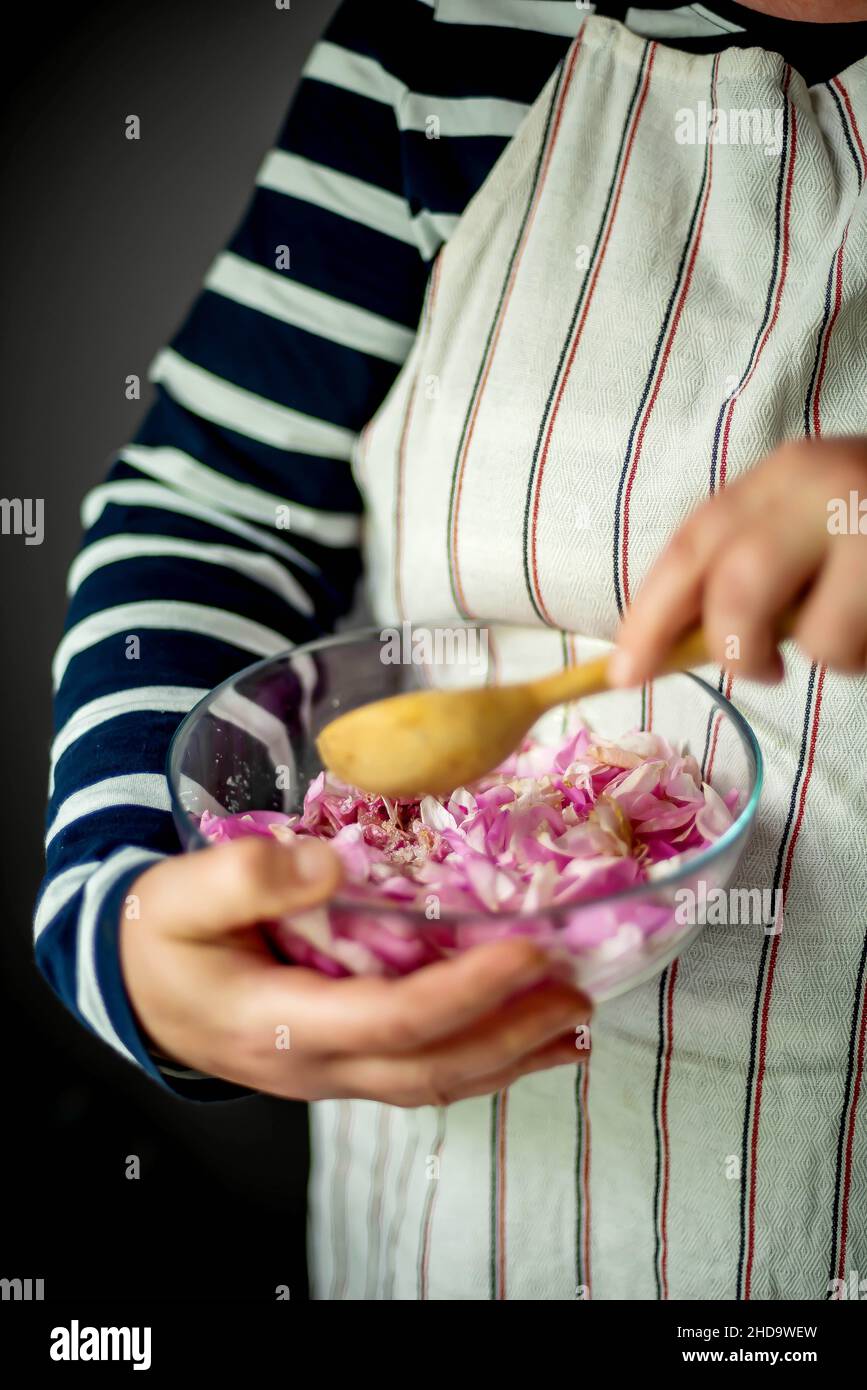 Frau, die in der Küche rosa Rosenblütenmarmelade zubereitet Stockfoto