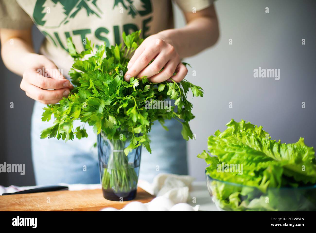 Anonyme Frau hackt Petersilie / Koriander Stockfoto