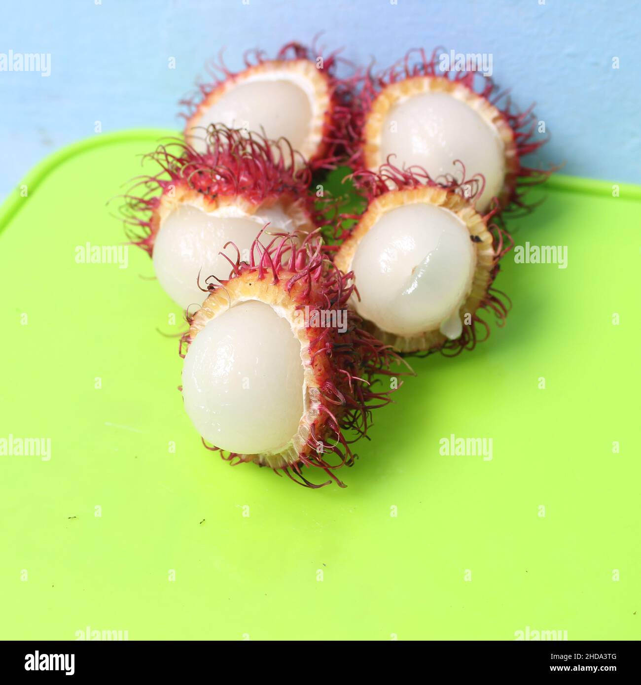 Nahaufnahme eines geöffneten Rambutans auf einem grünen Hintergrund Stockfoto