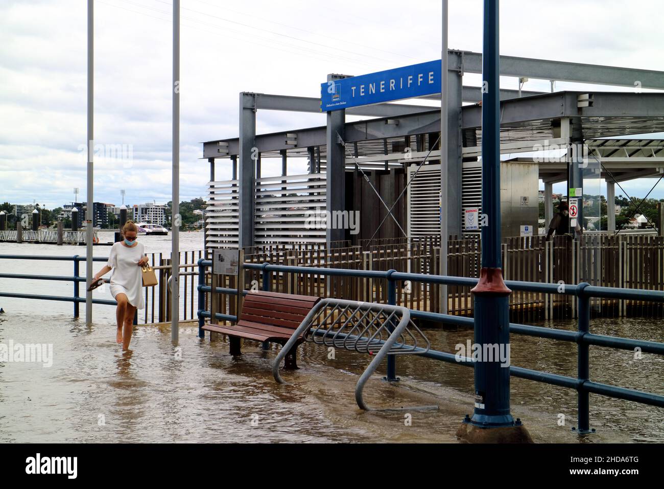 Die Frau findet sich sorgfältig durch die Königsflut des Brisbane River Stockfoto