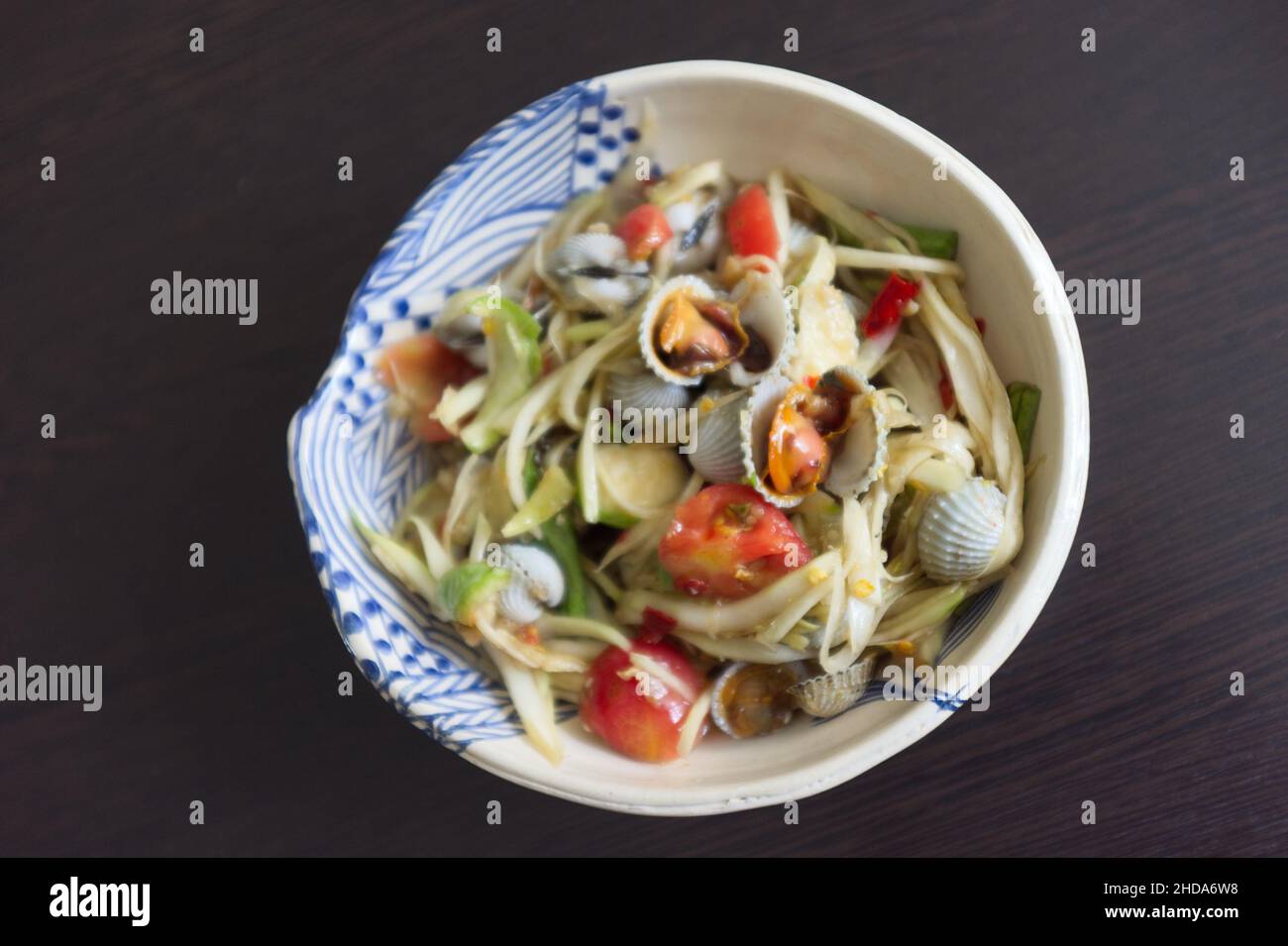 THAILÄNDISCHES ESSEN, würziger Papaya-Salat mit Herzmuschel Stockfoto
