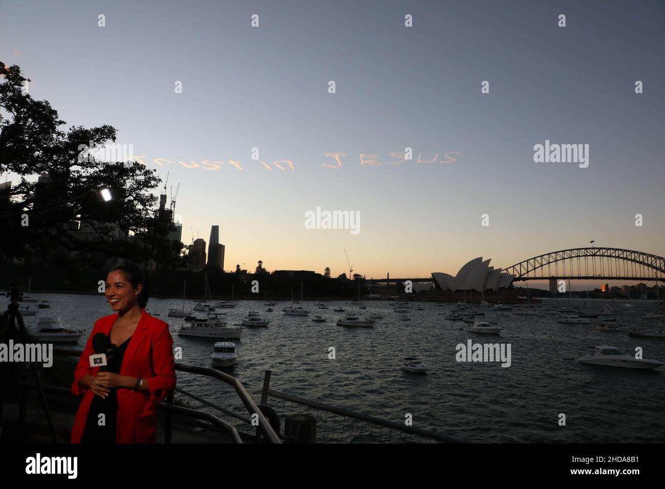 „Vertrauen in Jesus“, geschrieben am Himmel über Sydney, Australien, am Silvesterabend. Blick vom Mrs Macquaries Point im Royal Botanic Garden Sydney. Stockfoto