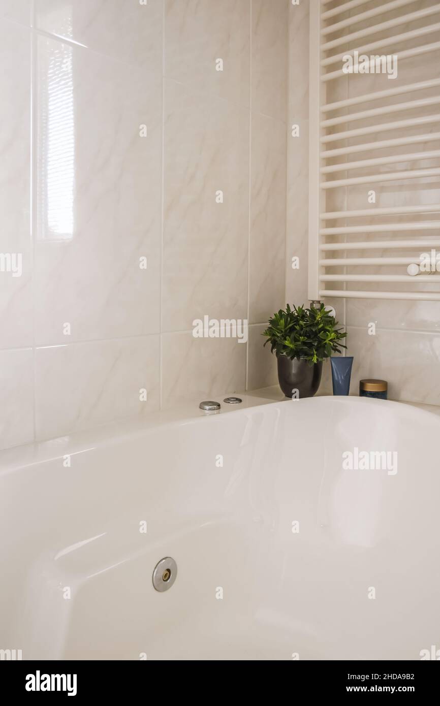 Gemütliche Badewanne mit Heizkörper und künstlichem Blumentopf  Stockfotografie - Alamy