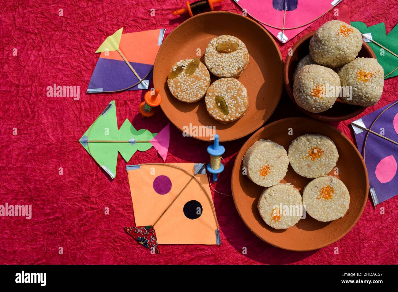 Til Gul oder süße weiße Sesamsamen Laddu mit Drachen und Phirki. Makar sankranti Festival Food Hintergrund. Til baati mit Laddo Stockfoto