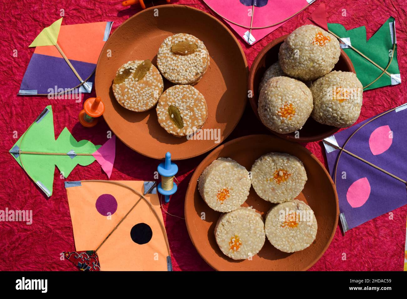 Til Gul oder süße weiße Sesamsamen Laddu mit Drachen und Phirki. Makar sankranti Festival Food Hintergrund. Til baati mit Laddo Stockfoto