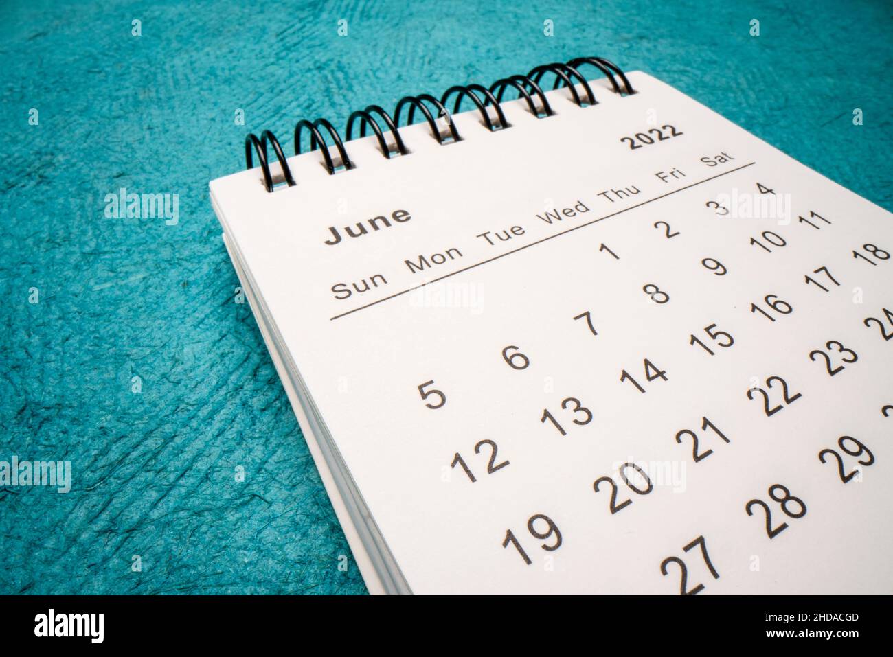 Juni 2022 - Spiralkalender gegen grünes handgemachtes Papier, Makroaufnahme mit niedrigem Winkel, Zeit- und Geschäftskonzept Stockfoto