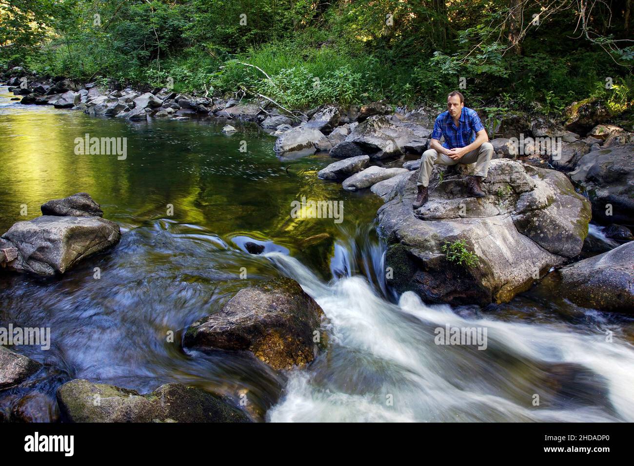 Ein nachdenklicher Mann sitzt in der Wutach-Schlucht im Schwarzwald Stockfoto
