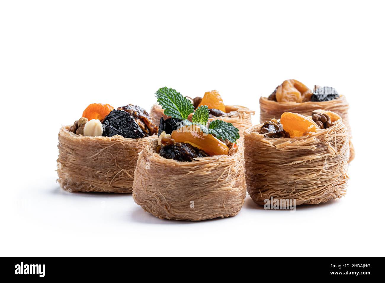 Traditionelle arabische und türkische Süßigkeiten Gebäck Dessert Kadaif mit Nüssen und getrockneten gesüßten Früchten isoliert auf weiß Stockfoto