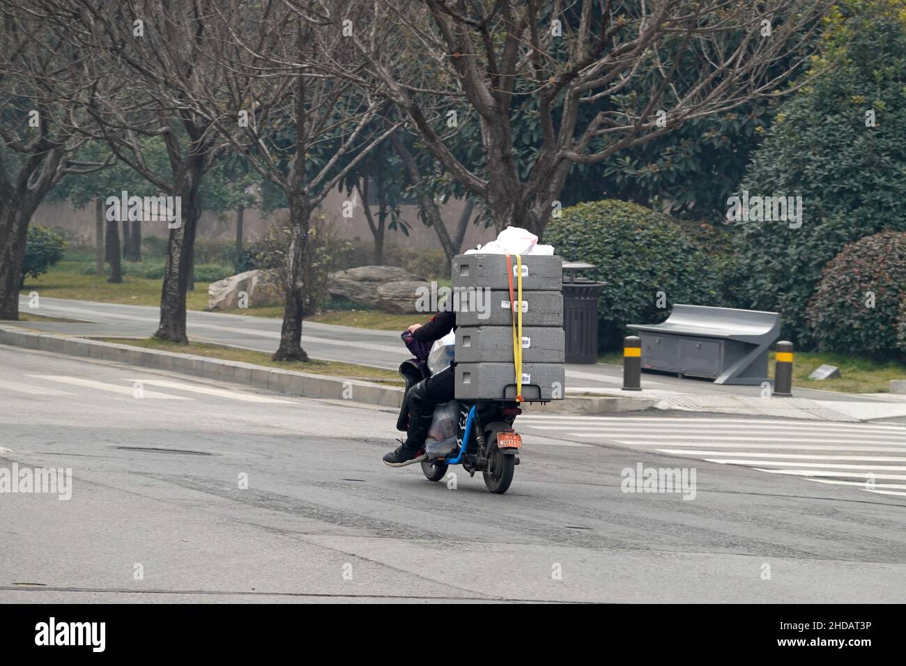 XI'AN, CHINA - 5. JANUAR 2022 - Kurier- und Reinigungskräfte fahren auf einer Straße in Xi'an, Provinz Shaanxi, China, 5. Januar 2022. Stockfoto