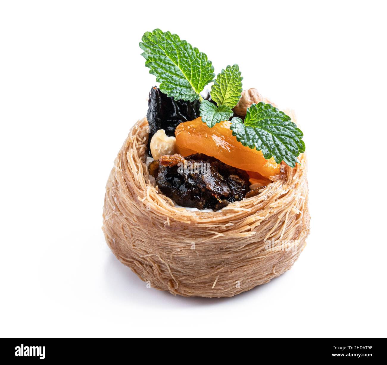 Traditionelle arabische und türkische Süßigkeiten Gebäck Dessert Kadaif mit Nüssen und getrockneten gesüßten Früchten isoliert auf weiß Stockfoto