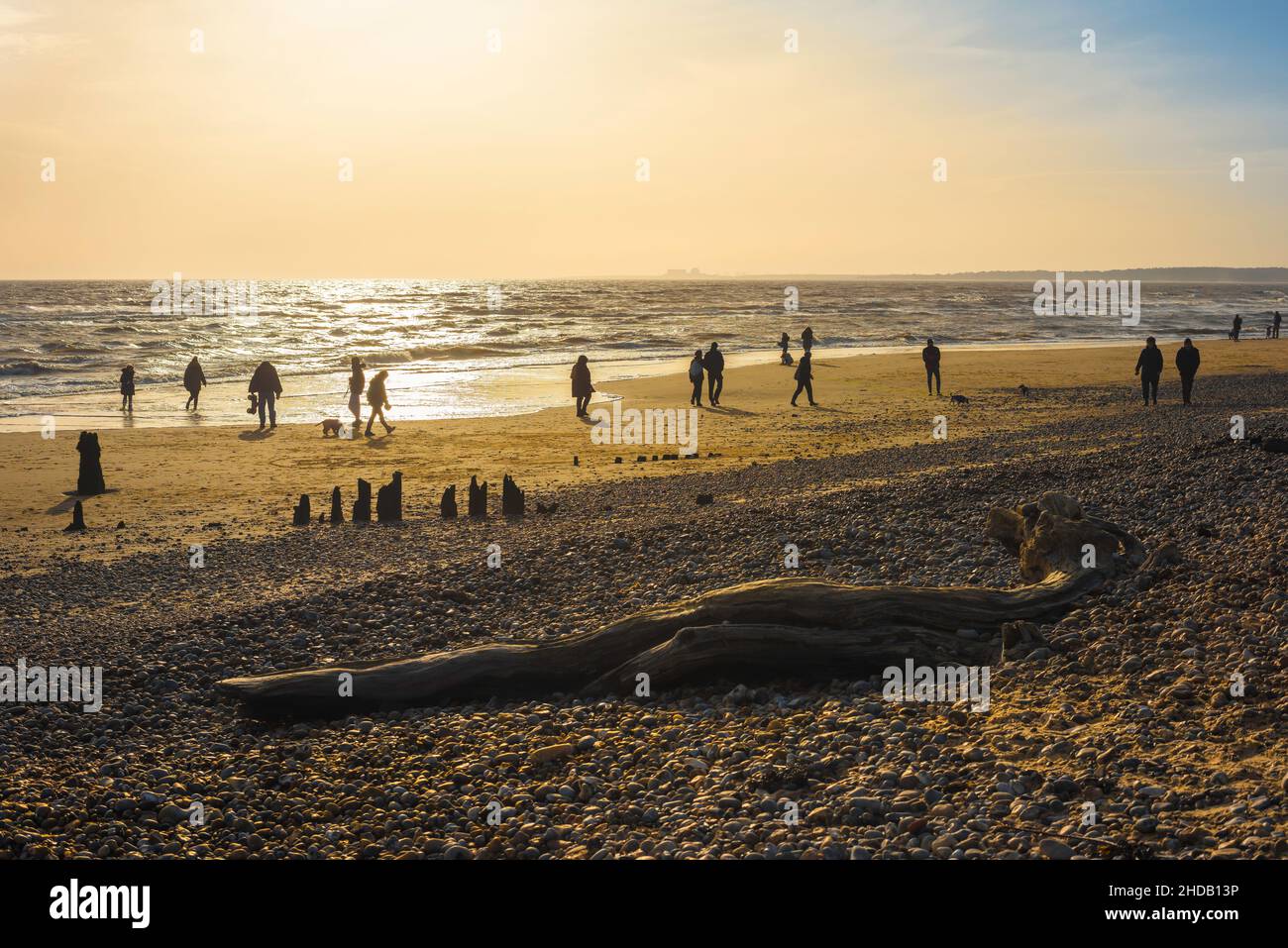 Winterspaziergang am Strand, Blick auf Menschen, die einen Spaziergang am späten Nachmittag an einem Strand entlang der Küste von East Anglian in Walberswick, England, Großbritannien, Unternehmen Stockfoto