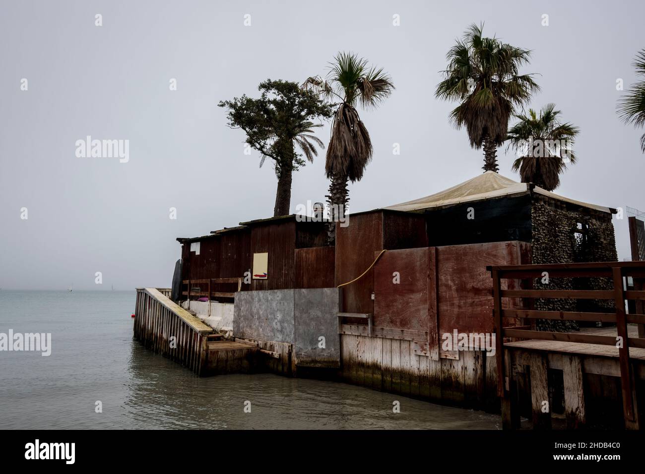 Strandszene Banner und Traumhäuser im Nebel bei Sonnenaufgang im ruhigen Meer mit Ruhe und Frieden. Stockfoto