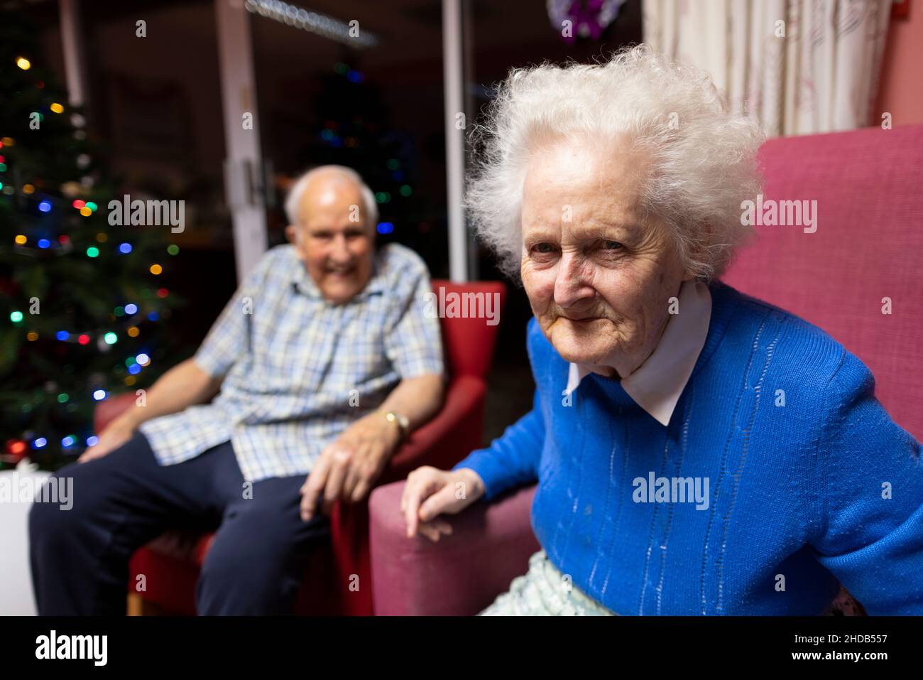 Ein älteres Paar in den Achtzigern sitzt zusammen in ihrem Pflegeheim, England, Vereinigtes Königreich Stockfoto