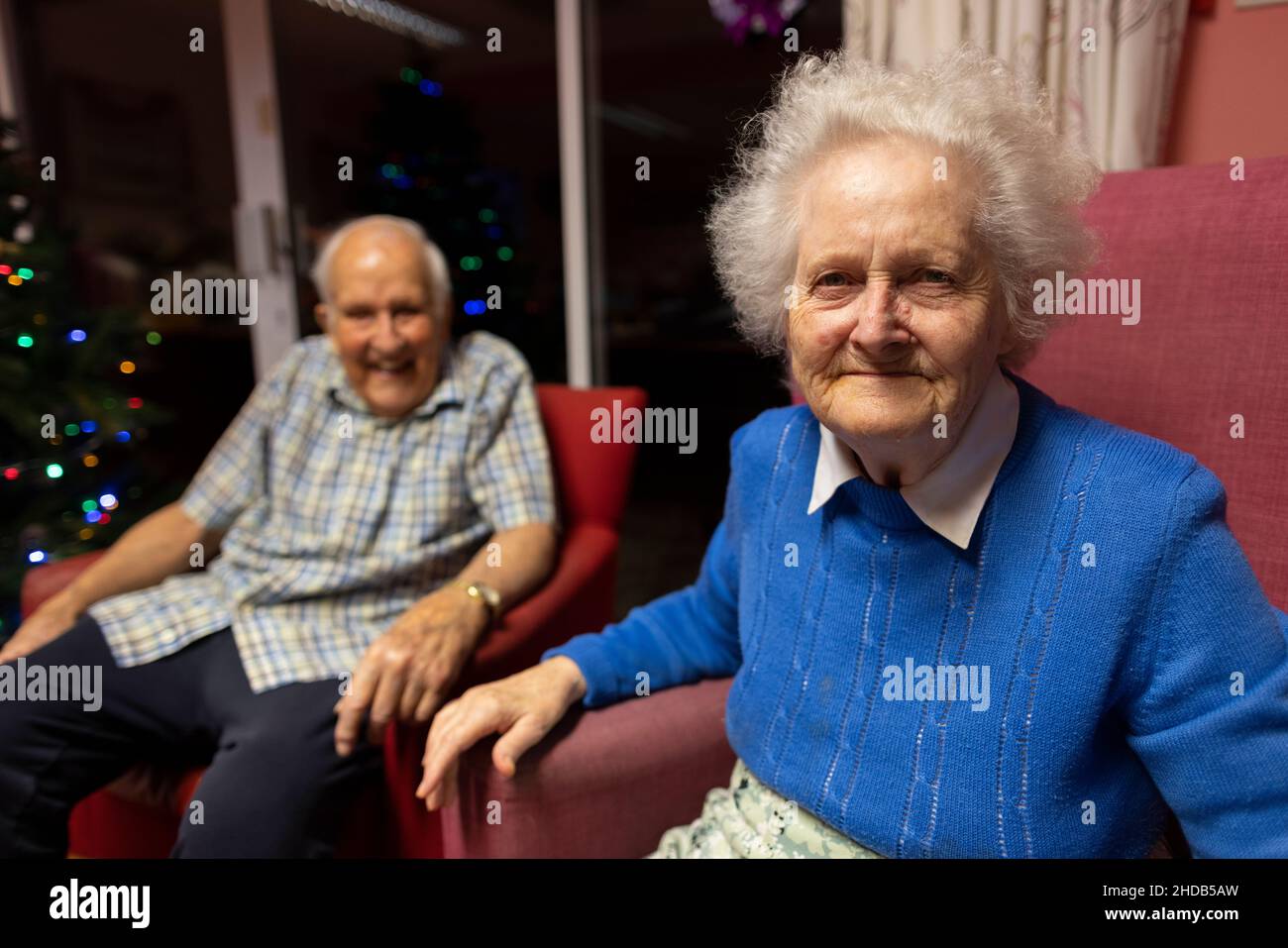 Ein älteres Paar in den Achtzigern sitzt zusammen in ihrem Pflegeheim, England, Vereinigtes Königreich Stockfoto